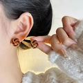Élégantes boucles d'oreilles perles rouge foncé avec cadre doré torsadé sur mannequin - Nœud Concentrique Rouge Ankela
