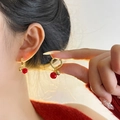 Élégantes boucles d'oreilles en argent S925 doré avec perles rouges sur un modèle - Boucles d'Oreilles Pendantes Cerise Rouge
