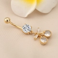 Macro shot of gold cherry belly button ring with butterfly knot and clear zircon stones - Gold