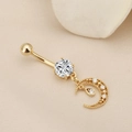 Detail of gold moon navel ring featuring a round zircon stud and filigree pendant - Gold