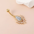 Makroansicht des goldenen Bauchnabelpiercings mit Tropfen-Zirkon und kleinen Kristallen - Blumen-Tropfenform / Gold