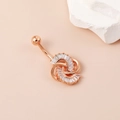 Eleganter roségoldener Bauchnabelpiercing mit diamantbesetztem Knotendesign auf warmem Grund - Roségold