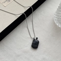 Minimalist long bead necklace featuring a black vintage radio-style pendant charm - Black