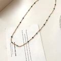 Minimalistische gouden ketting met blauw-witte emaille kralen op poëziekaart - Kleurrijke Emaille Kralenketting