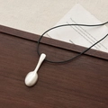 Irregular matte silver spoon pendant on black woven cord displayed on a wooden surface - Leather Cord Brushed Spoon Necklace