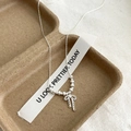 Elegante Franse parelketting met zilveren strik gepresenteerd op een beige linnen achtergrond - Ketting van verpletterd zilver met kantstrik
