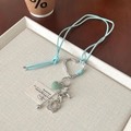 Light blue suede leather necklace with silver dog pendant and green heart stone - Blue