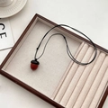 Pendentif gland en bois vintage avec cordon noir réglable sur plateau de bijoux - Collier Pomme de Pin en Bois Marron