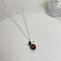 Vintage zilveren ketting met tijgeroog hanger gepresenteerd op een stenen ondergrond - Horizontale Balk Tijgeroog Hanger Ketting