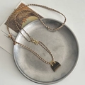 Tiger eye stone pouch pendant necklace with woven cord and golden bead details - Tiger Eye Bag Pendant Necklace