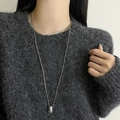 Polished silver teardrop pendant on a bead chain layered over a grey sweater - Bead Chain