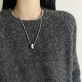 Polished silver water drop pendant necklace on gray sweater, minimalist metal jewelry style - Short Snake Chain