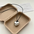 Minimalistische zilveren hartvormige hanger ketting met zwart koord in een papieren tray - Zilver