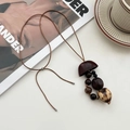 Retro etnische ketting met bruine zaadhanger en houten kralen aan een waskoord - Notendop Bel Ketting