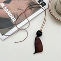 Artistieke houten schelpen ketting met bruine hanger en zwarte kraal aan lang koord - Lange Onregelmatige Zaad Stijl