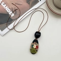 Retro halsketting met noot-hanger, gekleurde knopen en groene kwast aan bruin koord - Handgemaakte Houten Knoop Notendop Ketting