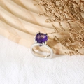 Sparkling purple amethyst cubic zirconia ring in silver prong setting on a textured surface - US 5 / Purple