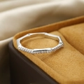 Macro shot of silver bamboo-style ring with white zircons on a yellow velvet box - US 6 / Silver