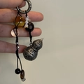 Detalle de un colgante de calabaza de bronce vintage con cuentas y cierre de resorte metálico - Estilo Chino de Calabaza