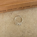 Minimalist silver grape cluster bead ring displayed on a textured brown background - Small Grape Cluster Ring