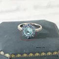 Macro detail of 14mm light blue floral halo ring with weight info 3.9g in a velvet box - US 6 / Gold