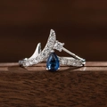 Detailaufnahme des Kronenrings mit blauem Saphir im Birnenschliff und weißen Diamanten - US 6 / Blau