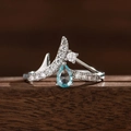 Makroaufnahme eines kronenförmigen V-Rings mit hellblauem Saphir und weißen Zirkonias - US 6 / Wasserblau