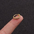 Minimalist gold hoop earring with five sparkling zircon stones held on a fingertip - 1# Gold