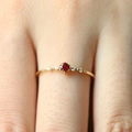 Eleganter Goldring mit rundem Rubin-Hauptstein und Seitendiamanten auf feinem Band - US 5 / Gold