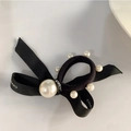 Dettaglio dell'elastico per capelli con fiocco nero, perle eleganti e nastro con logo - Decorazione con Fiocco e Perle / Nero