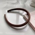 Detail of a brown knit headband featuring a premium handmade label in a vintage style - Dark Coffee