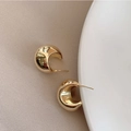 Detailopname van gouden holle C-oorbellen met een hooggepolijste spiegelafwerking - Koper / Goud (925 Sterling zilveren oorbelstift)