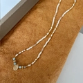 Macro shot of handcrafted beaded necklace with cream seed beads and yellow teardrop pendant - Creamy White Natural Stone Pendant Necklace