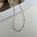Detalle de collar de cuentas de colores con turquesa, perlas y cadena dorada - Estilo de Cuentas Marrón