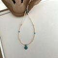 Detail of freshwater pearl necklace with turquoise pendant and golden accents on beige pulp - White Seed Bead Green Pendant Necklace