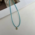 Detalle de cuentas turquesas y colgante de corazón dorado con estilo vintage francés - Estilo de Cuentas de Corazón Azul