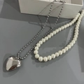 Detail of silver titanium heart pendant and white pearl necklace on grey background - White Artificial Pearl Necklace and Heart Necklace Set / White