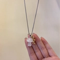 Detail shot of a pink quartz mushroom pendant with golden bead clusters on a steel chain - Clear Quartz Mushroom
