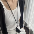 Détail du petit sac de cou minimaliste en cuir noir avec bouton pression et cordon long - Sac Demi-cercle Noir