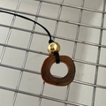 Long necklace featuring a brown textured bone pendant and golden bead on black cord - Gold Hollow Copper Bead / Brown