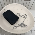 Minimalist black leather mini chain bag with silver beaded strap on a ceramic tray - Black