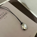 Minimalist silver pebble pendant with high-polish finish on a black woven cord necklace - Bottle Pendant / Black Braided Rope / Silver
