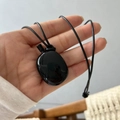 Minimalist long sweater necklace featuring a polished black stone pendant and woven cord - Bottle Pendant / Black Braided Rope / Black