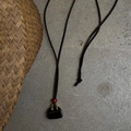 Chic handbag-shaped necklace with black pendant and red bead on a long cord - Obsidian Bag Style