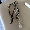 Detailopname van een zilveren lepelhanger aan een zwart-wit gevlochten verstelbaar koord - Nieuwe Zwarte Driestrengs Gevlochten Touw Lepel Ketting