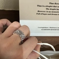 Nahaufnahme eines silbernen Spitzenrings mit Blumenmuster im Vintage-Stil am Finger - Silberring mit Kreuz-Zirkonia