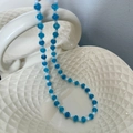 Handmade beaded necklace with translucent blue and white round beads in ceramic bowl - Blue Beaded Necklace