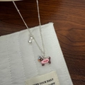 Silver necklace with pink enamel dachshund and bone charms on a rustic wood background - Pink Dress Dog Necklace