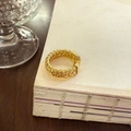 Eleganter goldener geflochtener Ring auf Vintage-Papier mit luxuriöser Ästhetik - Goldener Dicker Gewebter Ring