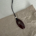 Minimalist long sweater necklace with deep reddish-brown hollow oval pendant and silver bead - Dark Red (Black Cord)